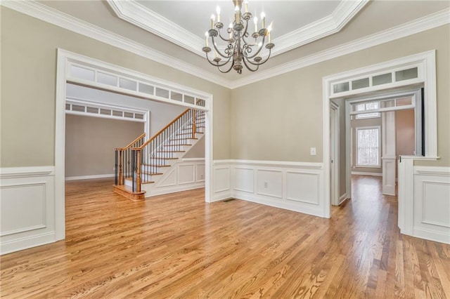 interior space featuring crown molding, light hardwood / wood-style flooring, and a notable chandelier