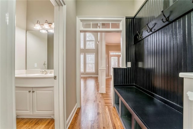 mudroom featuring sink, ornamental molding, and light hardwood / wood-style floors