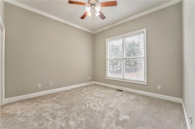 spare room featuring crown molding, light colored carpet, and ceiling fan