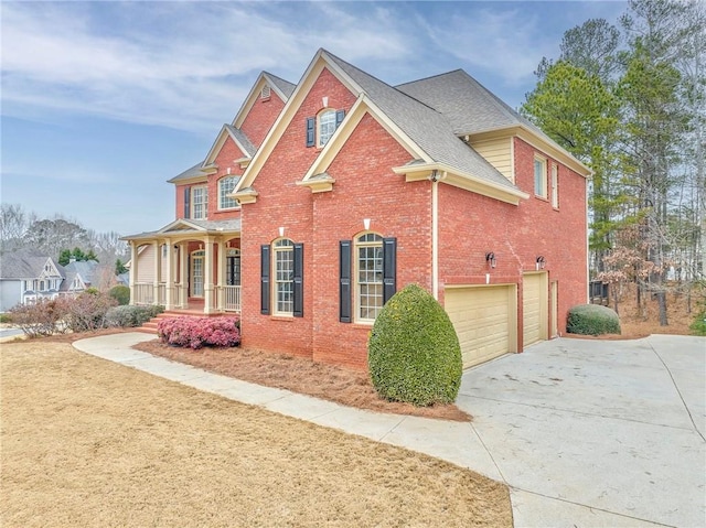 view of side of home featuring a garage and covered porch