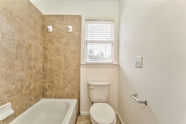 bathroom with toilet and tiled shower / bath combo