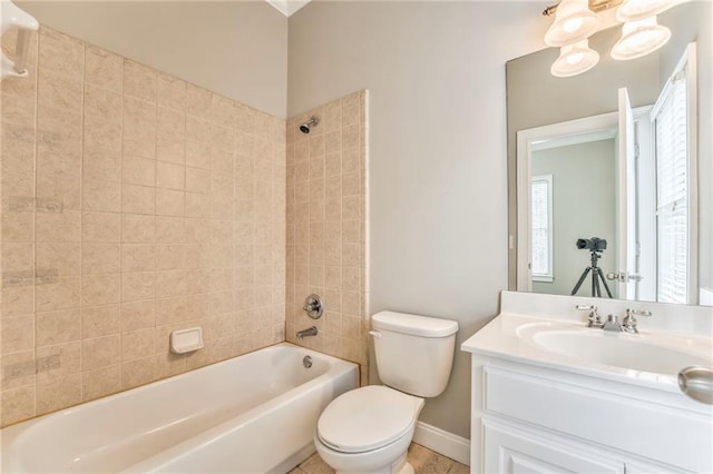 full bathroom with tiled shower / bath, vanity, an inviting chandelier, and toilet