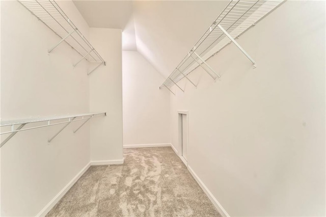 spacious closet featuring light carpet and lofted ceiling