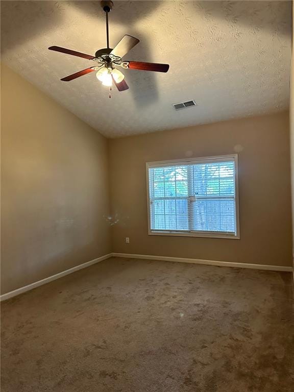 empty room with ceiling fan, a textured ceiling, vaulted ceiling, and carpet