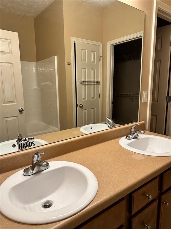 bathroom with shower / bathtub combination, a textured ceiling, and vanity