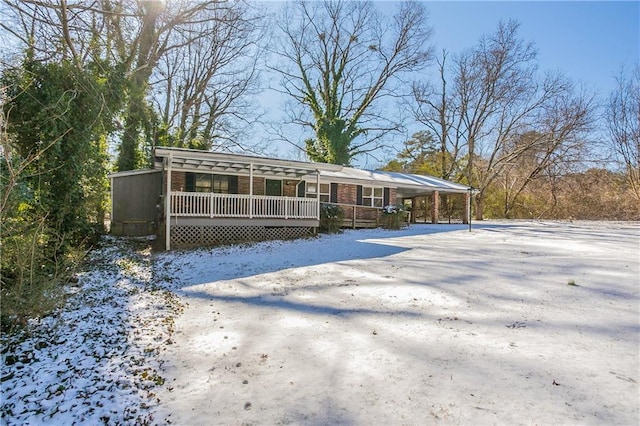 snow covered back of property featuring a porch