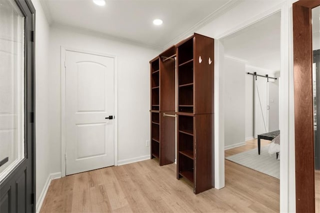 walk in closet with light hardwood / wood-style floors and a barn door