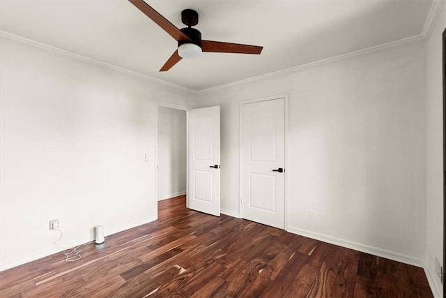 spare room featuring dark wood-type flooring, ornamental molding, and ceiling fan