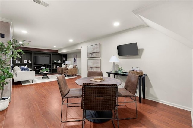 dining area featuring crown molding and hardwood / wood-style flooring