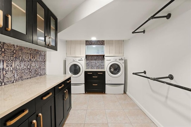 clothes washing area with cabinets, light tile patterned floors, and independent washer and dryer