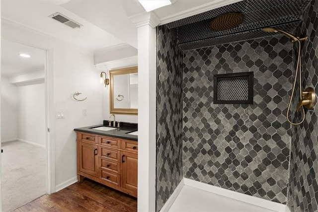 bathroom featuring walk in shower, vanity, crown molding, and hardwood / wood-style flooring