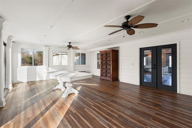 interior space featuring wood walls, ceiling fan, dark hardwood / wood-style flooring, and french doors