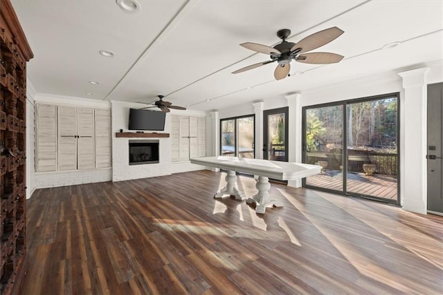 interior space with ceiling fan, a fireplace, and hardwood / wood-style floors