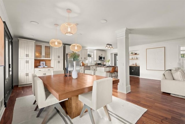 dining room with dark wood-type flooring and ornate columns