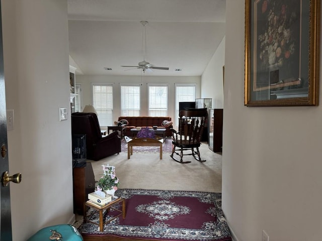 living room featuring carpet floors, ceiling fan, and vaulted ceiling