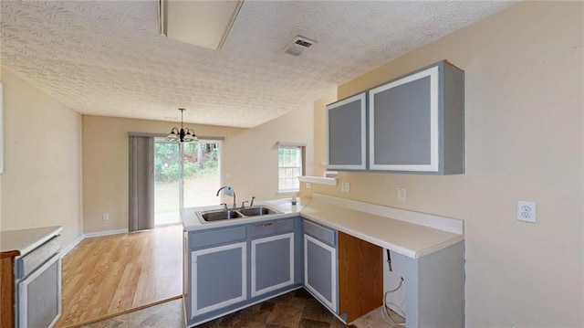 176 Silver Fox Trl, Dallas, GA 30157 - kitchen with a sink, a peninsula, a textured ceiling, light countertops, and pendant lighting