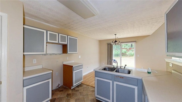 176 Silver Fox Trl, Dallas, GA 30157 - kitchen featuring a sink, a textured ceiling, a peninsula, stone finish floors, and light countertops