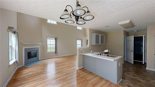 176 Silver Fox Trl, Dallas, GA 30157 - kitchen with a sink, a chandelier, a peninsula, light countertops, and a textured ceiling