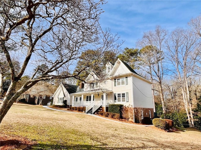 view of front of house featuring covered porch and a front yard