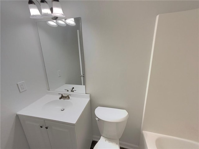 bathroom with vanity, a bathing tub, and toilet