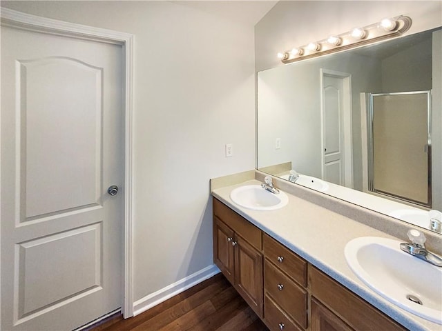 bathroom with walk in shower, wood-type flooring, and vanity