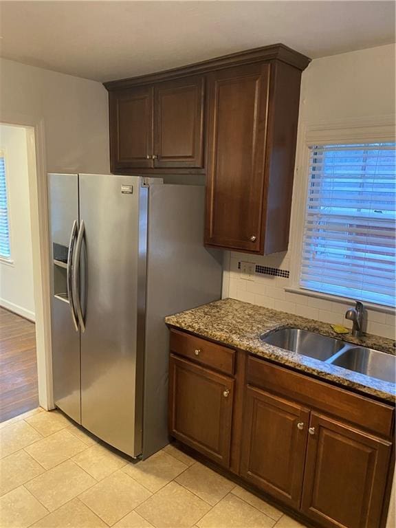 kitchen with sink, stainless steel fridge, plenty of natural light, and light tile patterned flooring