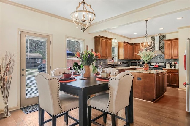 dining area featuring crown molding, light wood-style flooring, recessed lighting, and a chandelier