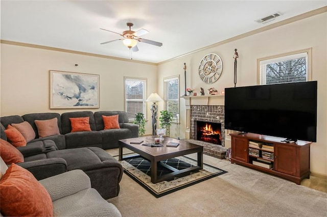 living area featuring visible vents, a brick fireplace, carpet, ceiling fan, and ornamental molding