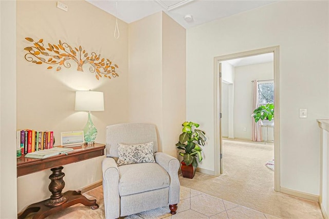 sitting room featuring attic access, carpet flooring, and baseboards