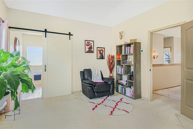 living area featuring a barn door and carpet