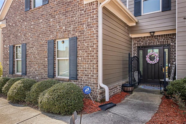 view of exterior entry featuring brick siding