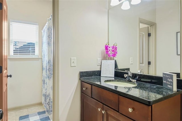 full bath featuring vanity, baseboards, and tile patterned flooring