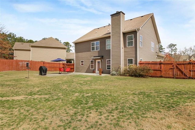 rear view of property featuring a lawn, a chimney, a fenced backyard, a patio, and a gate