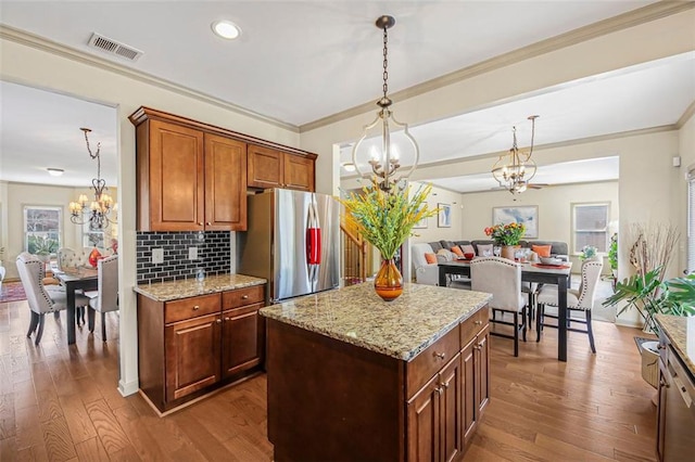 kitchen featuring dark wood-type flooring, a notable chandelier, visible vents, and freestanding refrigerator