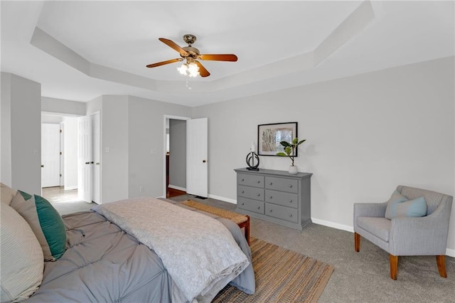 bedroom featuring ceiling fan, carpet, a raised ceiling, and baseboards