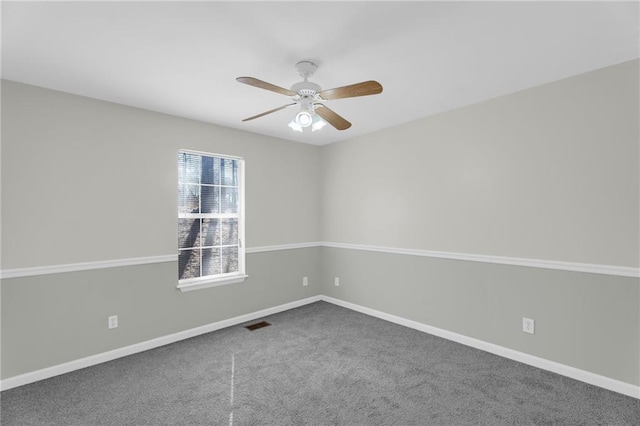 carpeted spare room featuring visible vents, baseboards, and a ceiling fan