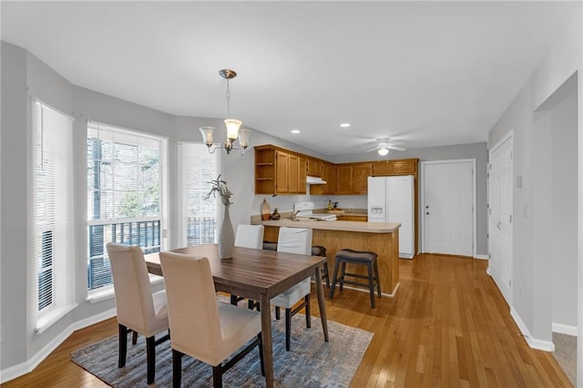 dining area with ceiling fan with notable chandelier, light wood-style flooring, recessed lighting, and baseboards