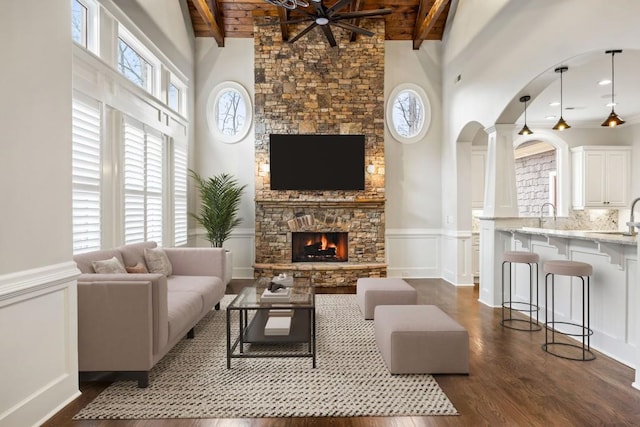 47 Fern Leaf Way, Newnan, GA 30265 - living room featuring plenty of natural light, a fireplace, a high ceiling, beam ceiling, and arched walkways