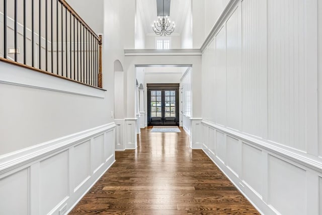 47 Fern Leaf Way, Newnan, GA 30265 - entryway featuring a decorative wall, arched walkways, a chandelier, dark wood-style floors, and wainscoting