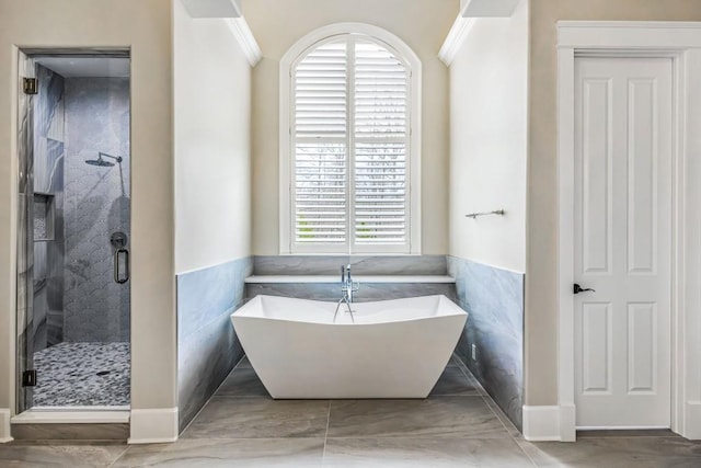 47 Fern Leaf Way, Newnan, GA 30265 - bathroom featuring a freestanding tub, a shower stall, tile walls, crown molding, and wainscoting