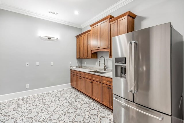 47 Fern Leaf Way, Newnan, GA 30265 - kitchen with high end refrigerator, a sink, crown molding, brown cabinetry, and baseboards