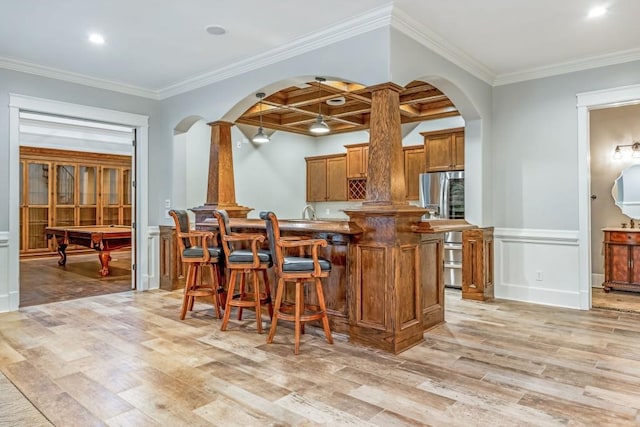 47 Fern Leaf Way, Newnan, GA 30265 - kitchen featuring brown cabinets, light wood-style floors, coffered ceiling, arched walkways, and stainless steel refrigerator with ice dispenser