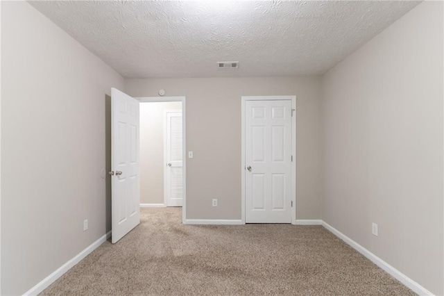 3732 Landgraf Cv, Decatur, GA 30034 - unfurnished bedroom featuring a textured ceiling, light colored carpet, and baseboards