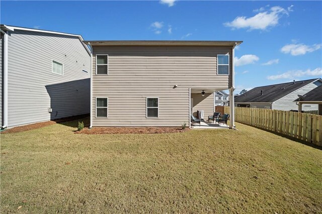 back of property featuring a lawn, ceiling fan, and a patio area