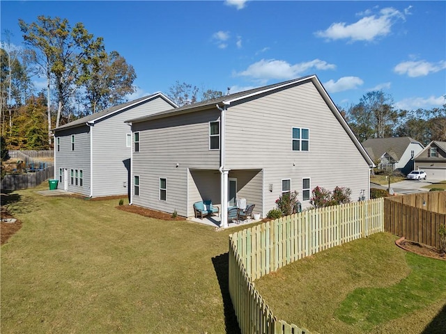 rear view of property with a yard and a patio