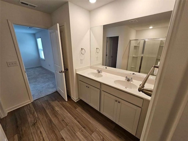 bathroom featuring wood-type flooring, vanity, and an enclosed shower