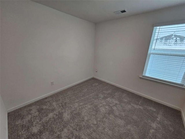 empty room with dark colored carpet