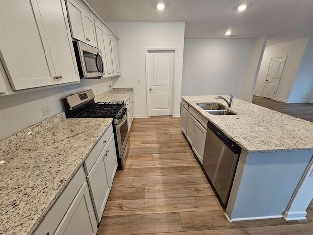 kitchen featuring sink, white cabinetry, stainless steel appliances, and a kitchen island with sink