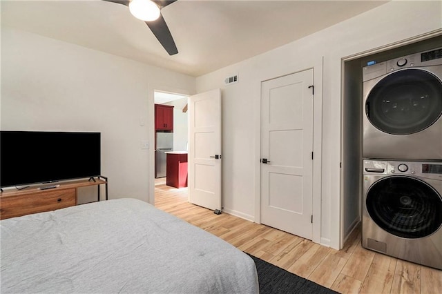 834 Lower Bell Creek Rd, Hiawassee, GA 30546 - bedroom featuring stacked washing machine and dryer, light wood-type flooring, freestanding refrigerator, and ceiling fan