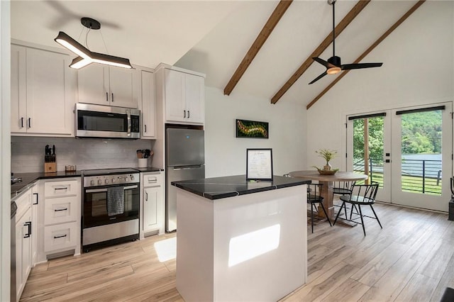 834 Lower Bell Creek Rd, Hiawassee, GA 30546 - kitchen featuring appliances with stainless steel finishes, high vaulted ceiling, decorative backsplash, dark countertops, and a kitchen island
